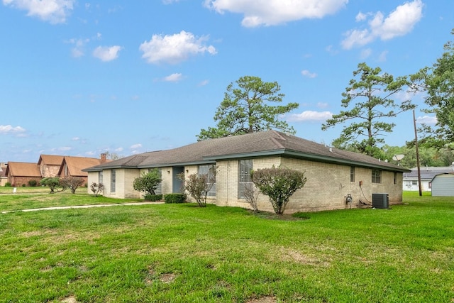 exterior space featuring central AC unit and a lawn