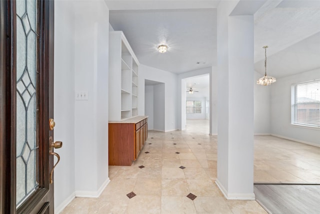 entrance foyer featuring light tile patterned floors and ceiling fan with notable chandelier