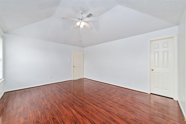 spare room with ceiling fan, dark wood-type flooring, and vaulted ceiling