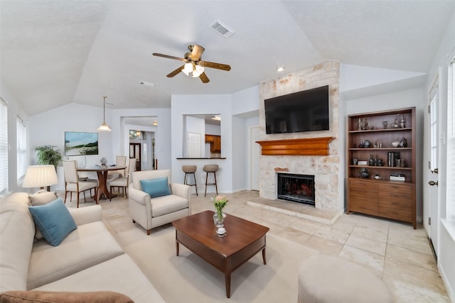 tiled living room featuring lofted ceiling, built in features, ceiling fan, and a fireplace