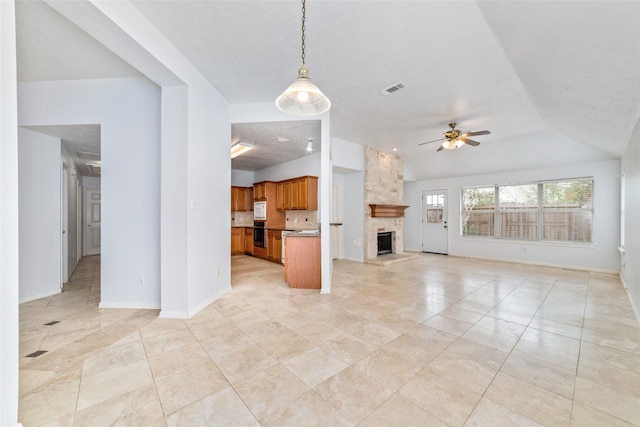 unfurnished living room with ceiling fan and a fireplace