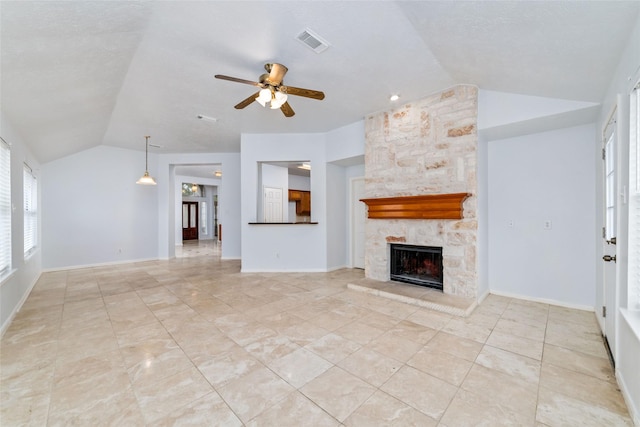 unfurnished living room with ceiling fan, vaulted ceiling, and a stone fireplace