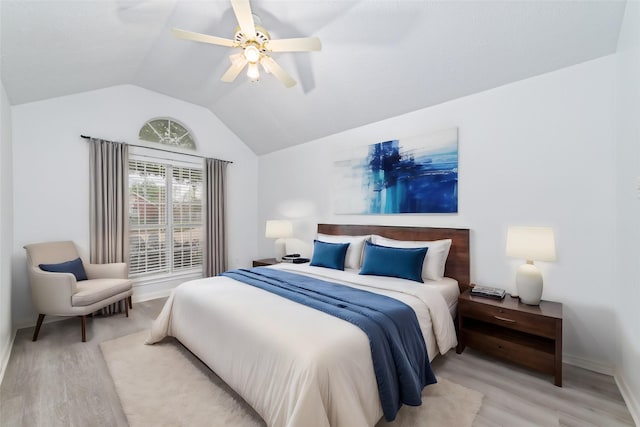 bedroom featuring ceiling fan, light hardwood / wood-style floors, and lofted ceiling