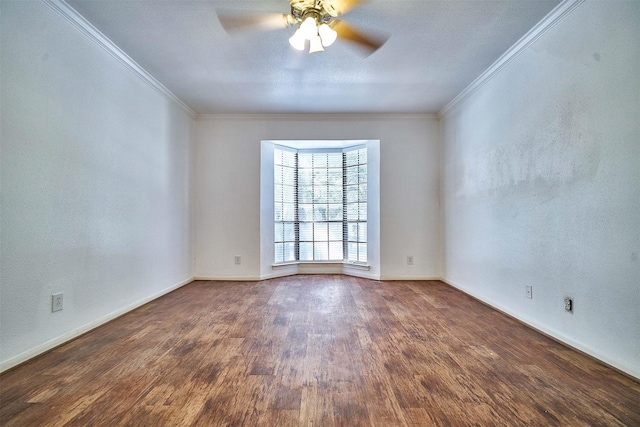 empty room featuring ceiling fan, dark wood-type flooring, and crown molding