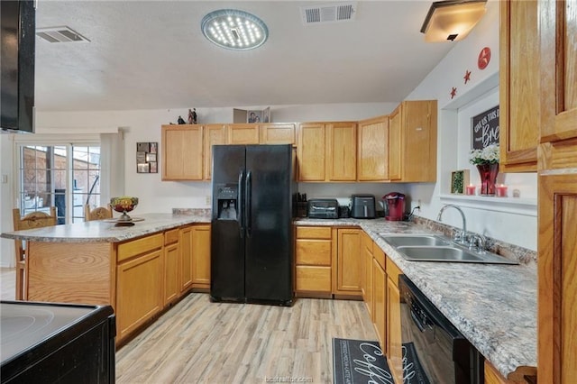 kitchen with black appliances, light brown cabinetry, sink, kitchen peninsula, and light wood-type flooring