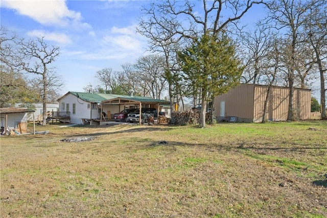 view of yard featuring a carport and an outdoor structure