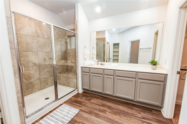 bathroom with wood-type flooring, an enclosed shower, and vanity