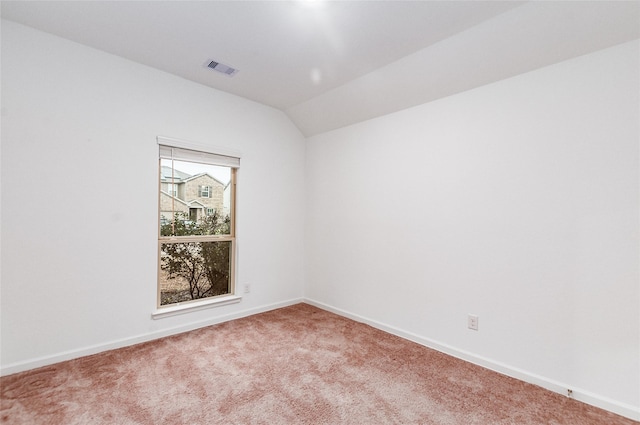 empty room featuring lofted ceiling, a healthy amount of sunlight, and carpet