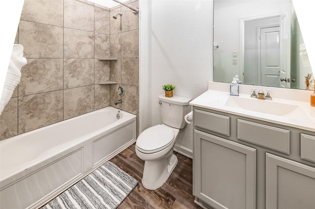 full bathroom featuring wood-type flooring, toilet, vanity, and tiled shower / bath