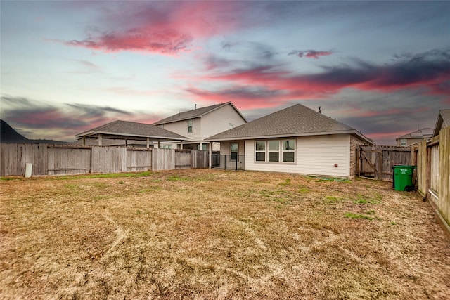 back house at dusk with a yard