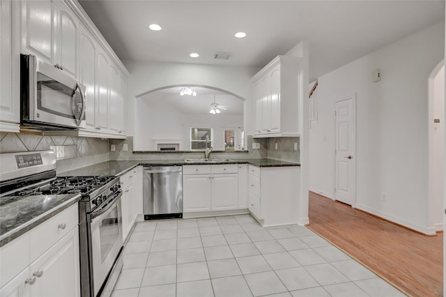 kitchen with white cabinets, dark stone countertops, and stainless steel appliances