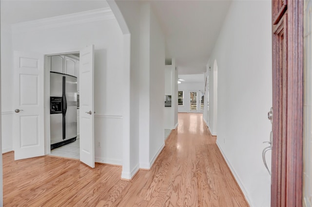 hallway featuring light wood-type flooring and crown molding