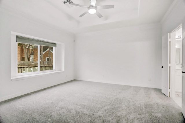 carpeted spare room featuring ceiling fan, ornamental molding, and a tray ceiling