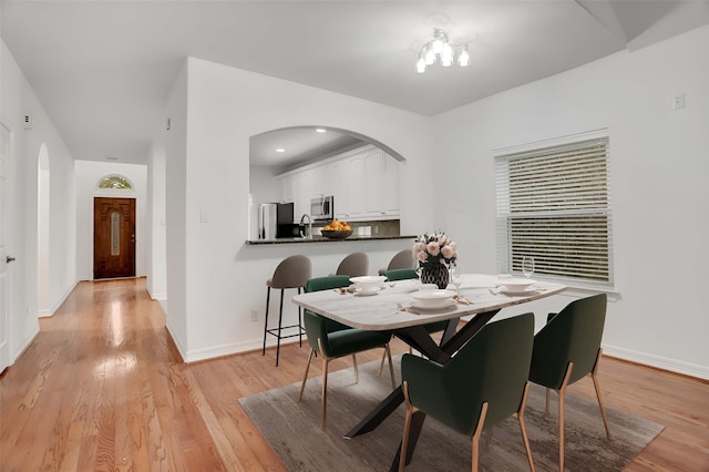 dining space featuring light wood-type flooring and sink