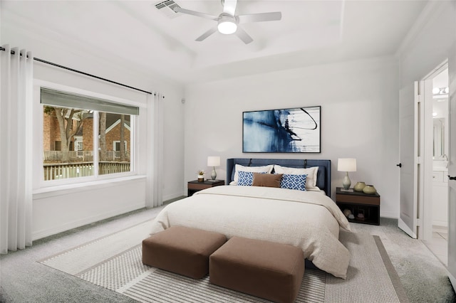 carpeted bedroom with ceiling fan and a tray ceiling