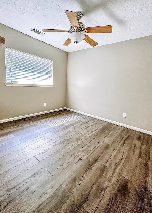 empty room featuring light hardwood / wood-style floors, a textured ceiling, and ceiling fan