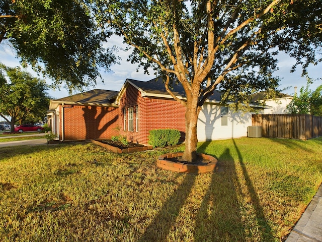 view of side of home with a yard and central AC unit