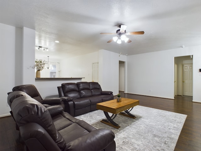 living room featuring a textured ceiling, ceiling fan, and dark hardwood / wood-style floors