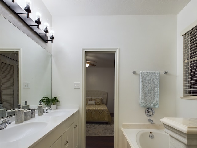 bathroom with ceiling fan, a bathtub, and vanity