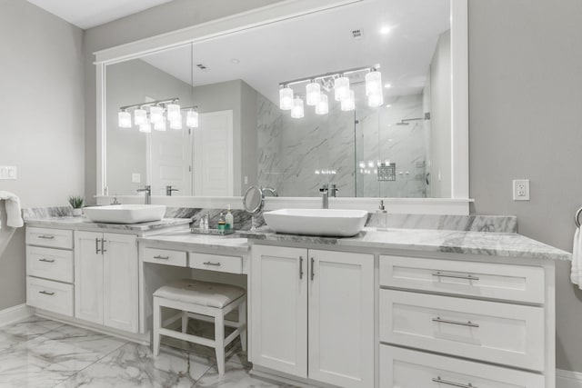 bathroom featuring a shower with shower door and vanity