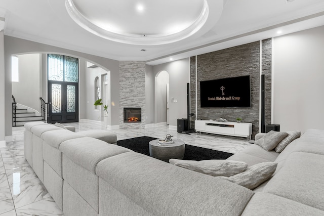 living room featuring a stone fireplace, french doors, and a tray ceiling