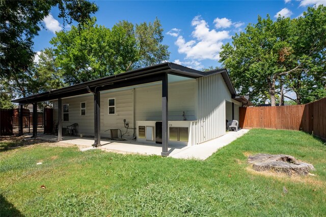 rear view of house with a yard and a patio