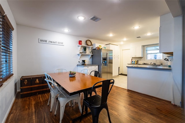 dining space with baseboards, visible vents, wood finished floors, and recessed lighting