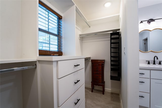 walk in closet with light tile patterned floors and a sink