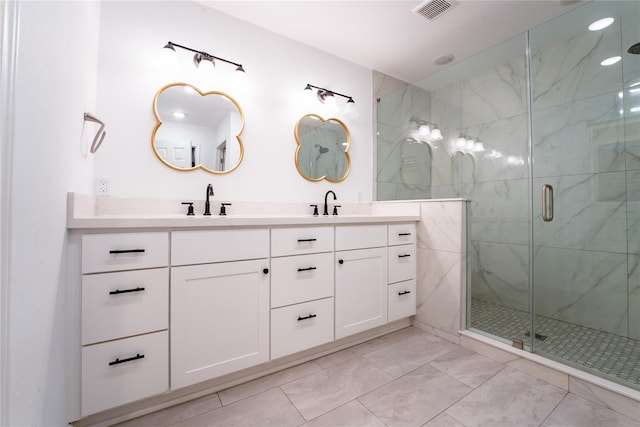 bathroom with visible vents, a sink, a marble finish shower, and double vanity