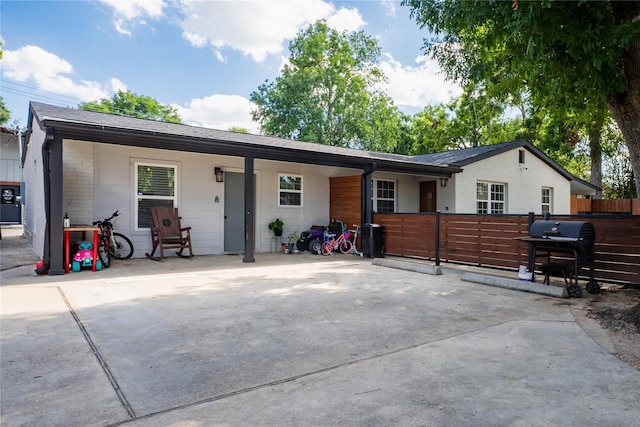 ranch-style home featuring brick siding, roof with shingles, and fence