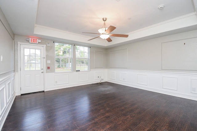 spare room with a raised ceiling, ceiling fan, dark hardwood / wood-style floors, and crown molding