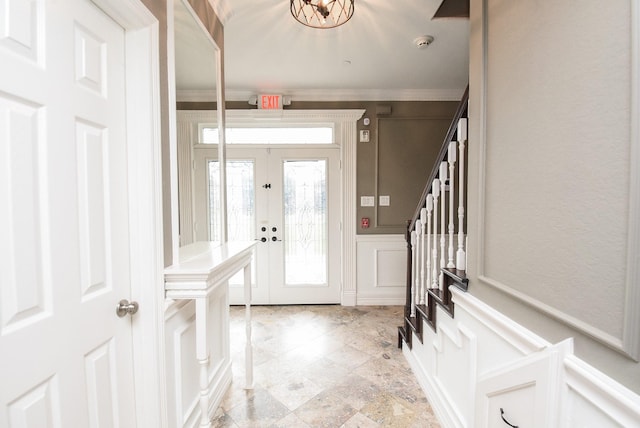 foyer entrance with crown molding and french doors