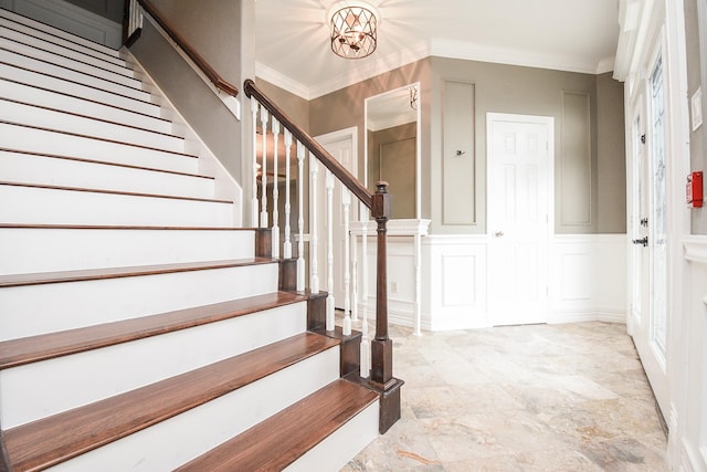 entrance foyer featuring ornamental molding and a notable chandelier