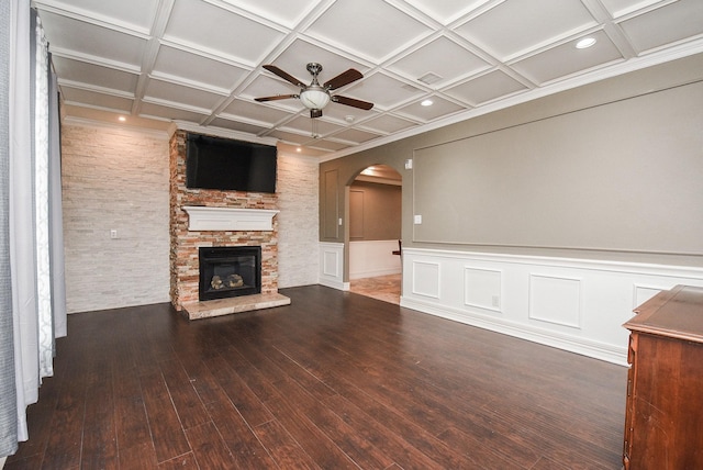 unfurnished living room with a fireplace, dark wood-type flooring, ceiling fan, and coffered ceiling