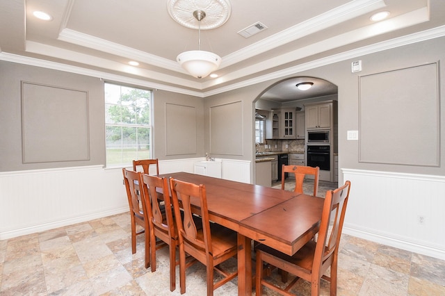 dining room with ornamental molding and a tray ceiling