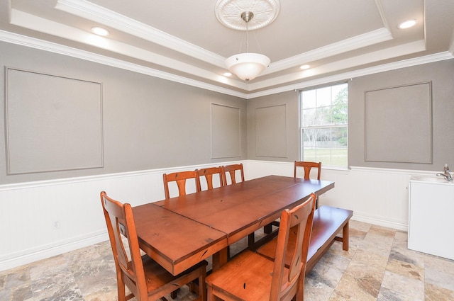 dining room with a tray ceiling and crown molding