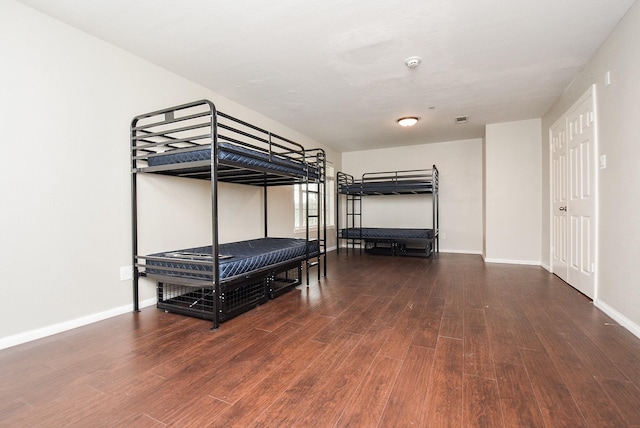 unfurnished bedroom with dark hardwood / wood-style flooring