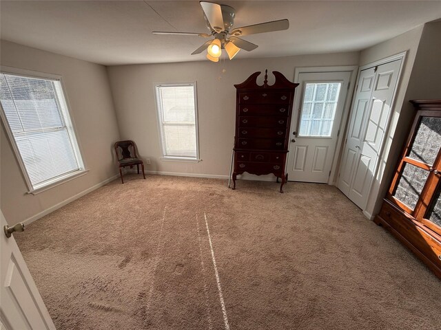 unfurnished room featuring ceiling fan, a wealth of natural light, and carpet floors