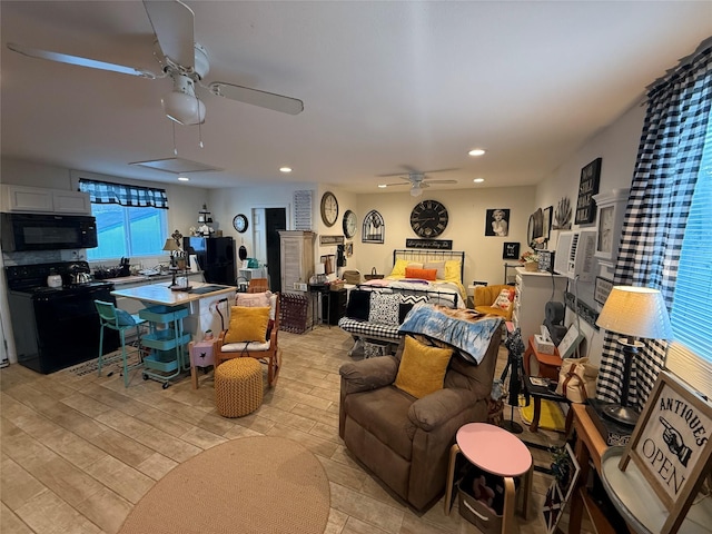 living room with ceiling fan and light hardwood / wood-style flooring