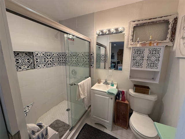 bathroom with toilet, vanity, an enclosed shower, and tile patterned flooring