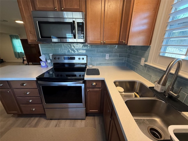 kitchen with decorative backsplash, sink, and stainless steel appliances