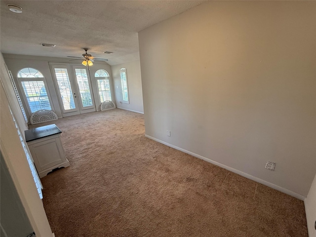 unfurnished room featuring light carpet, french doors, a textured ceiling, and ceiling fan