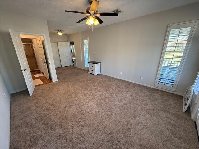 unfurnished bedroom featuring ceiling fan, carpet floors, and a textured ceiling