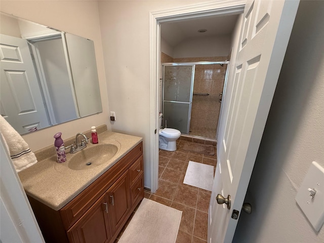 bathroom with toilet, tile patterned flooring, walk in shower, and vanity