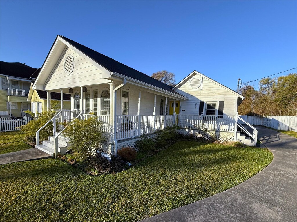 316 Vinsonia St, Morgans Point, TX 77571 - view of front of house featuring covered porch, fence, and a front lawn