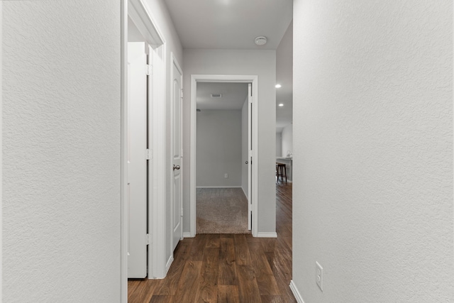 hallway with dark hardwood / wood-style flooring