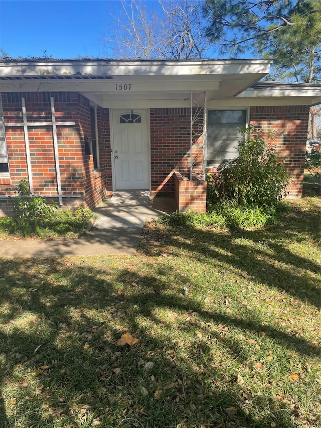 view of exterior entry featuring a yard