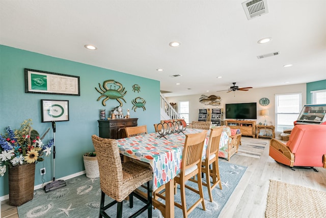 dining space with ceiling fan and light wood-type flooring