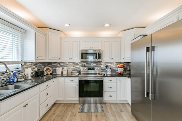 kitchen featuring light hardwood / wood-style floors, sink, stainless steel appliances, and white cabinetry