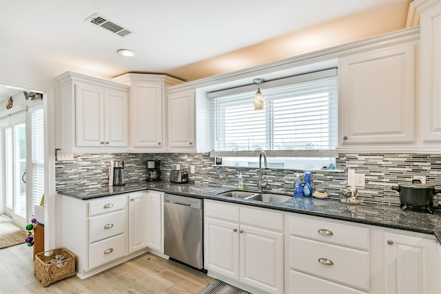 kitchen with white cabinets, dishwasher, dark stone counters, sink, and light wood-type flooring